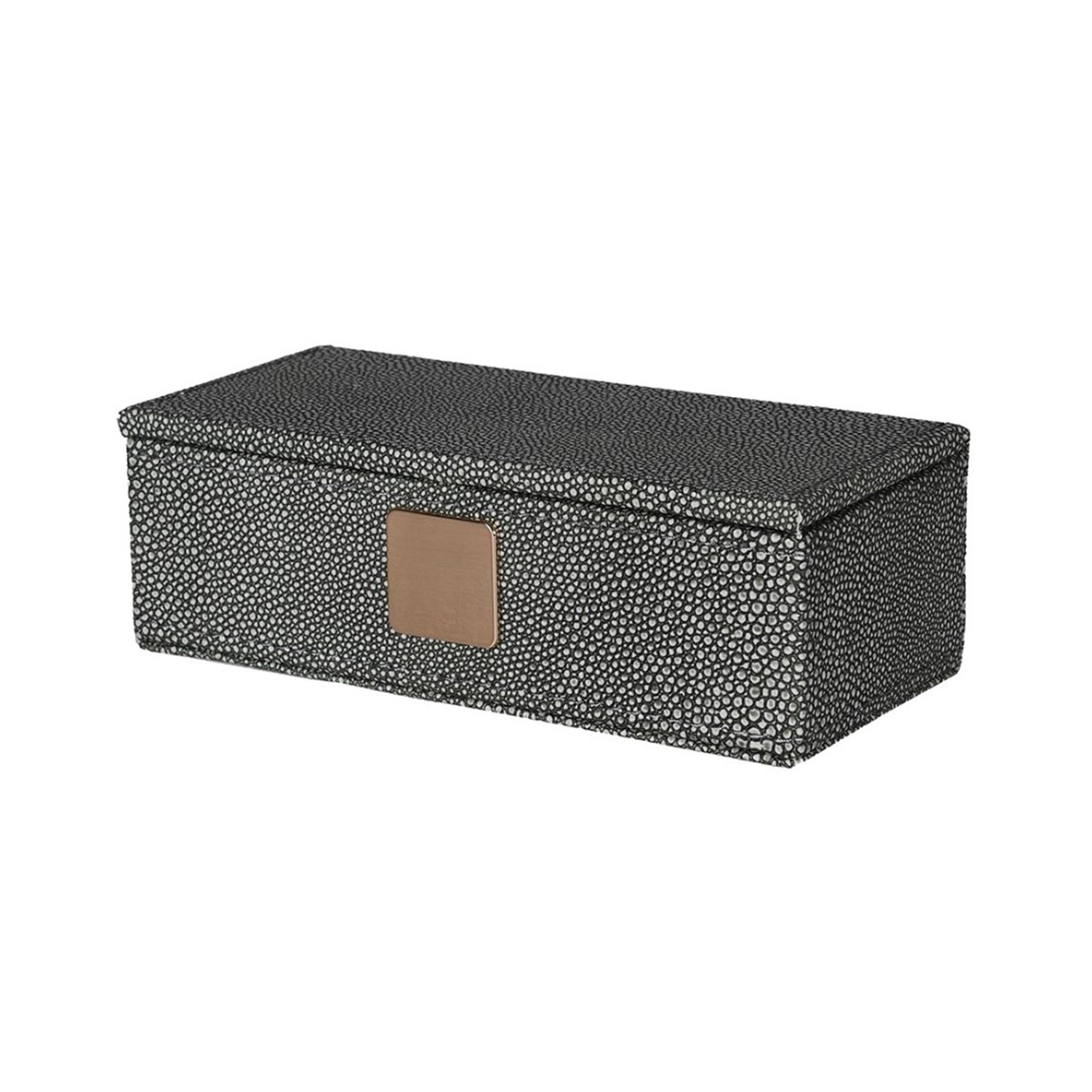 Faux shagreen lidded trinket box in dark grey colour. The small circular texture of the shagreen skin is in a pale grey, giving it a two tone effect. The box has a matt gold sqaure badge on the front.
Dimensions: H:60 W:180 D:85 mm